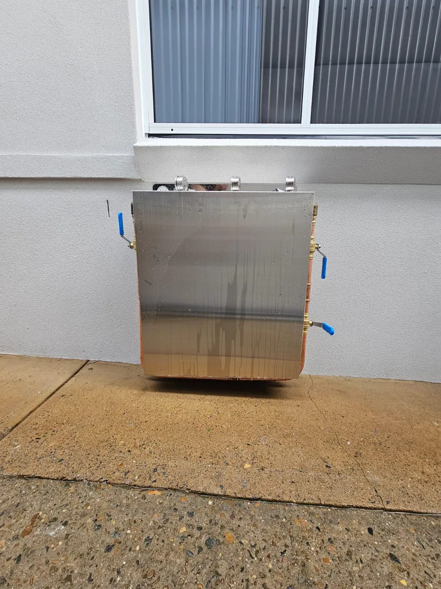Whole house filtration unit installed beside a garage wall